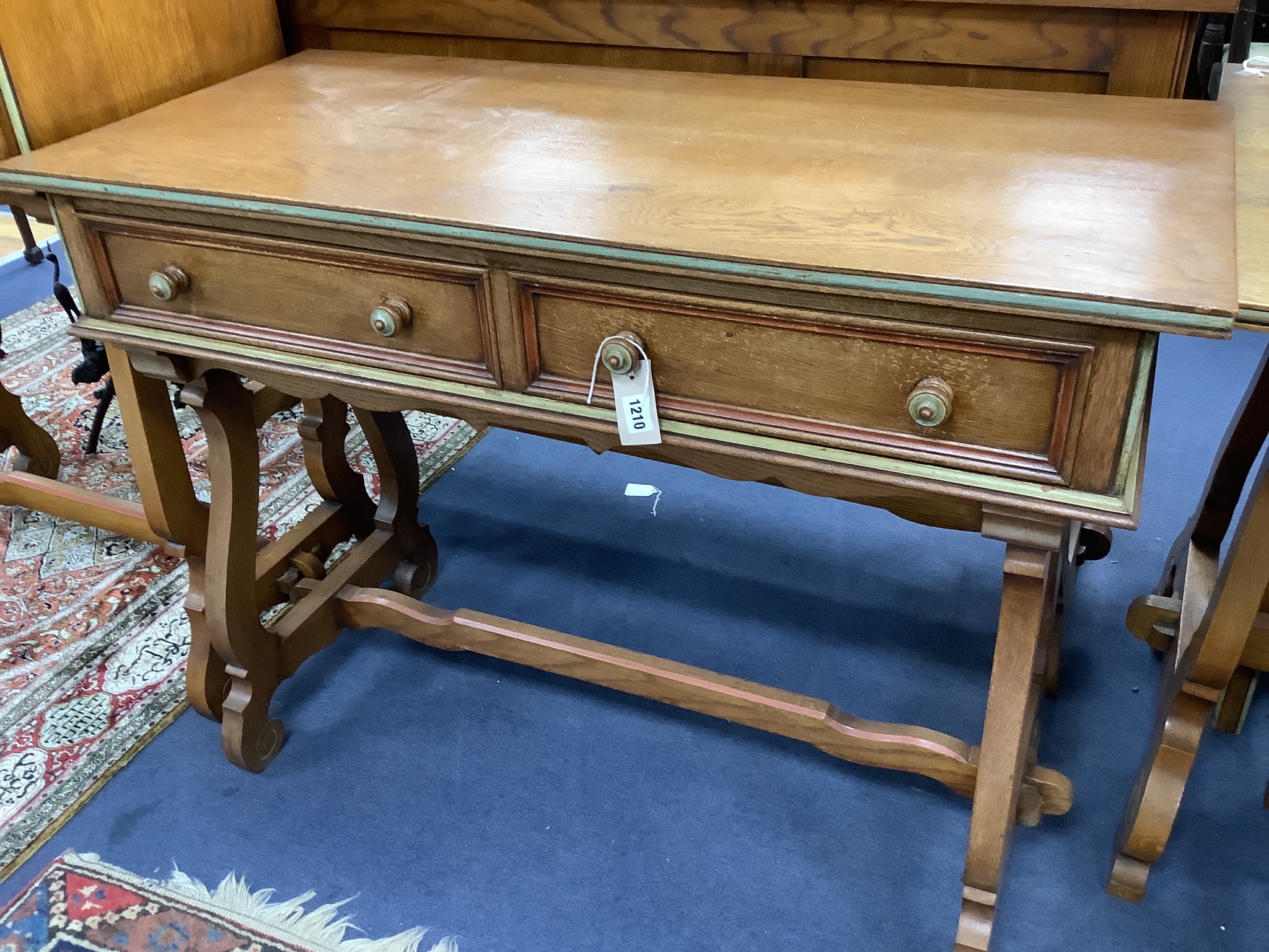 A Maple & Co oak dining suite of Italianate design, with carved and painted decoration and heraldic panels, comprising refectory table, six studded hide-covered chairs, sideboard, two-door cabinet on stand and a side tab